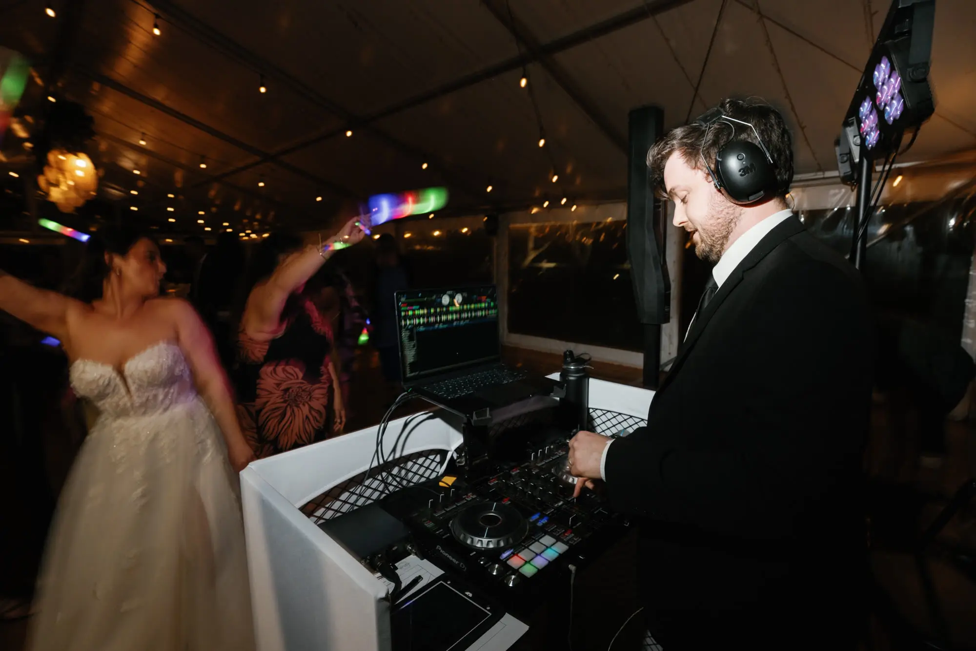A bride dancing at her wedding reception while Mitchell Martin, her Perth wedding DJ, plays behind her